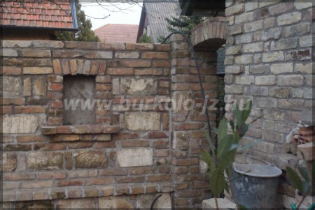 Bontott tégla-kő kerítésbe épült grillező.